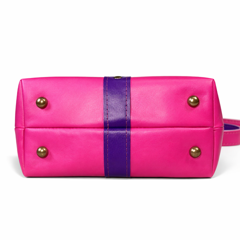 Bottom view of hot pink lambskin bag showing four antique brass protective purse feet and purple center leather detail