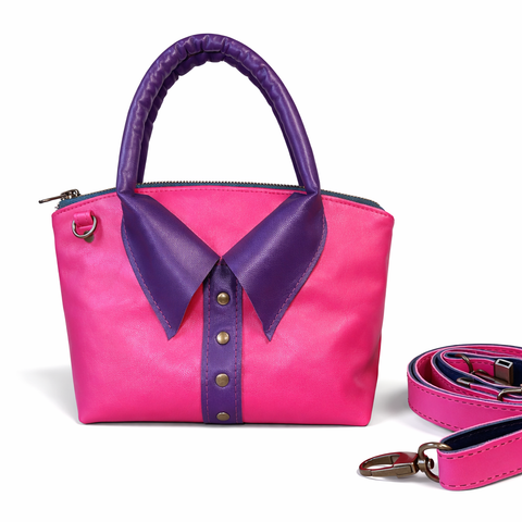Handmade hot pink leather collar bag with rolled purple top handle, antique brass studs, and detachable adjustable crossbody strap