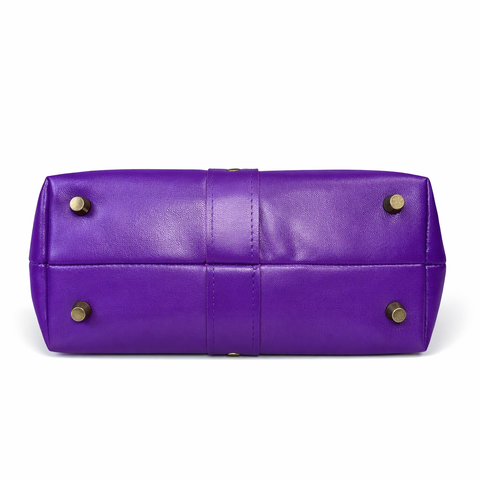 Bottom view of royal purple lambskin bag showing four antique brass protective purse feet and center leather detail