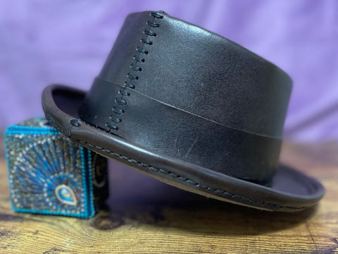 Back of Dark Brown Pork Pie Hat featuring hand stitching against a purple backdrop