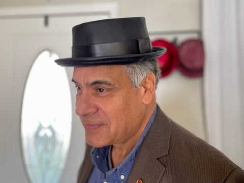 Man wearing a black leather pork pie hat