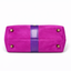 Bottom view of magenta suede collar bag showing four antique brass protective purse feet and purple lambskin center detail