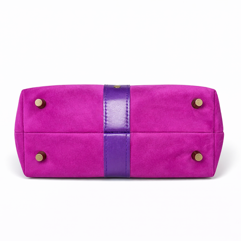 Bottom view of magenta suede collar bag showing four antique brass protective purse feet and purple lambskin center detail