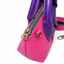 Close-up of YKK antique brass zipper pull and D-ring hardware on handmade hot pink lambskin leather bag