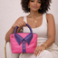 Handmade hot pink and purple lambskin leather bag with collar detail and rolled top handle, held by model — Inspired Leather Co.