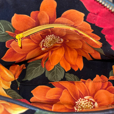 Floral fabric with orange flowers and a gold zipper on a black background