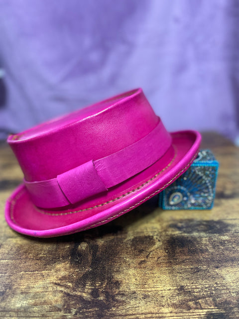 Pink Leather Pork Pie Hat with a pink hat band against a purple backdrop